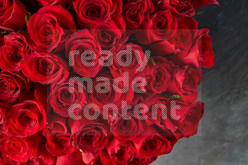 A luxurious bouquet of red roses on black marble background