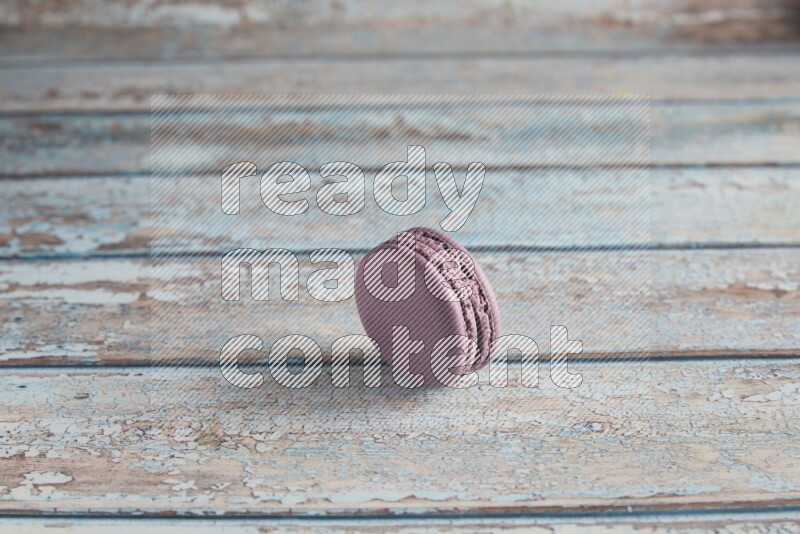45º Shot of Purple Blueberry macaron on light blue wooden background