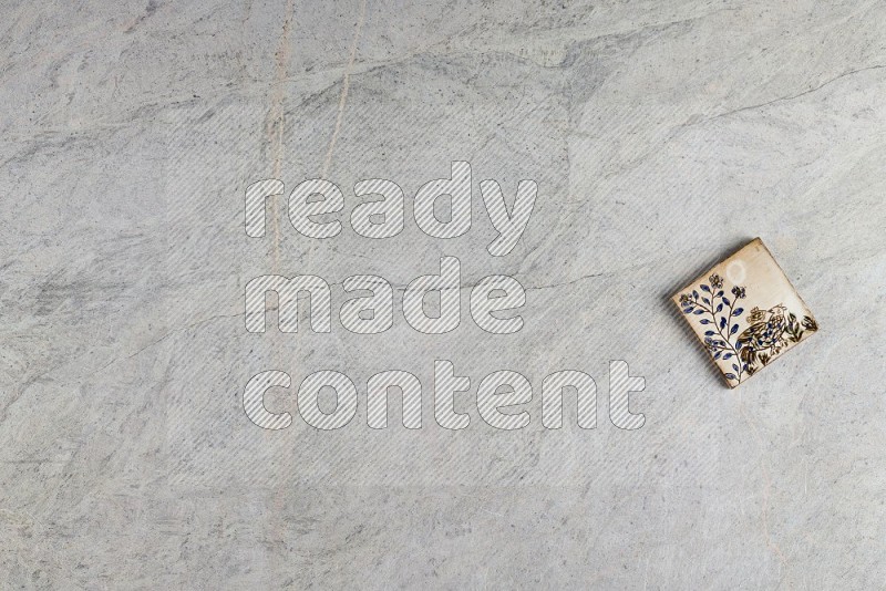 Top View Shot Of A Pottery Coaster tile On Grey Marble Flooring