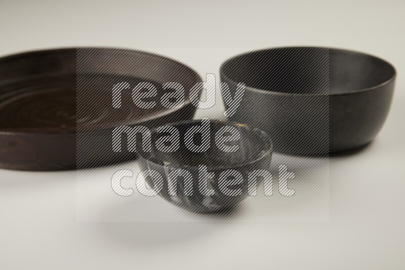 black pottery plate and black bowls on white background