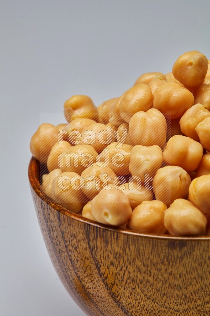 Close up shot of boiled chickpeas in a container on white background