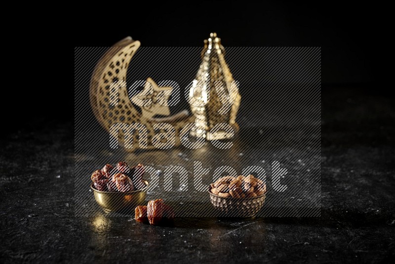 Dates in a metal bowl with almonds beside golden lanterns in a dark setup