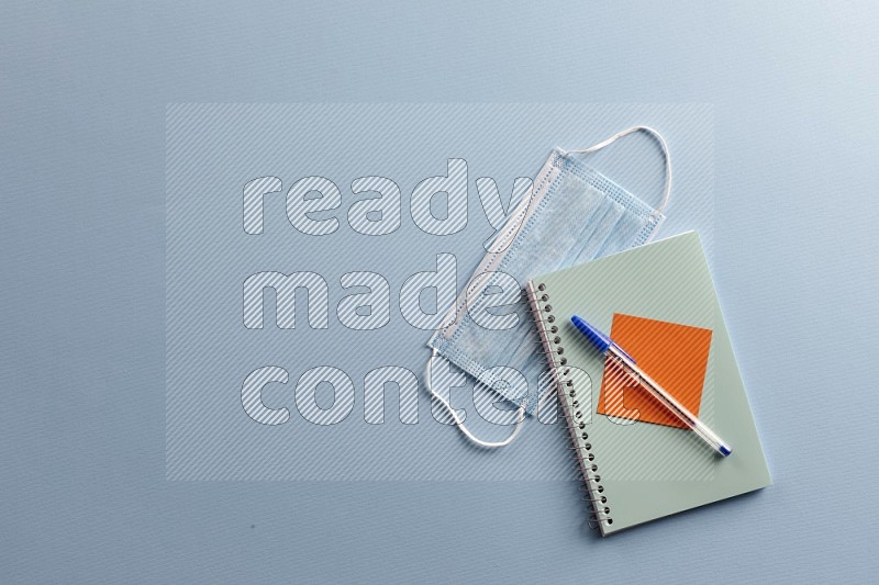 A blue notebook with school supplies on blue background (Back to school)