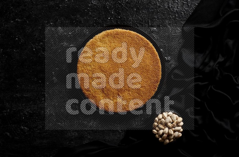 Konafa with nuts and honey in a dark setup