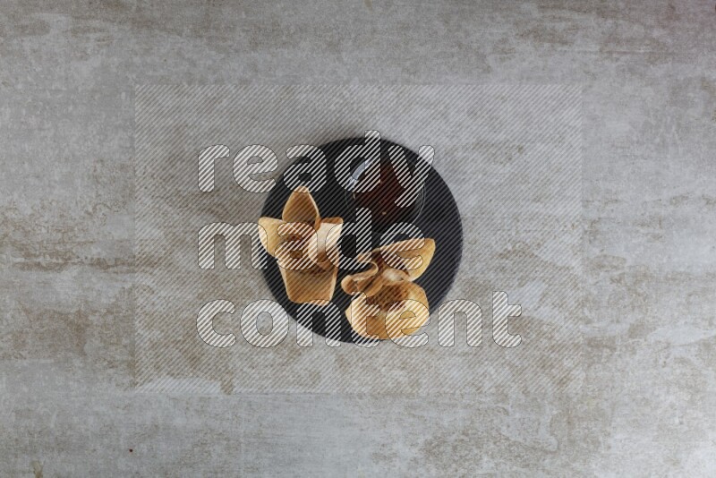 wonton cups with soy sauce ramkin on circle slate on grey textured counter top
