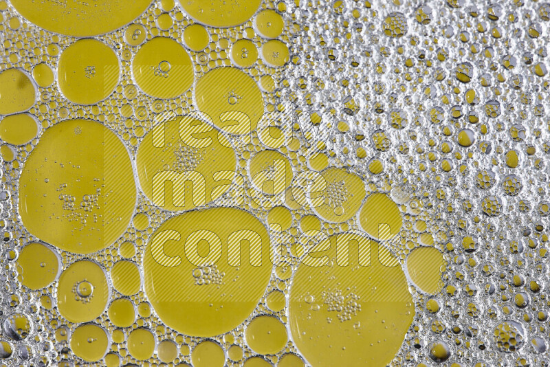 Close-ups of abstract soap bubbles and water droplets on yellow background