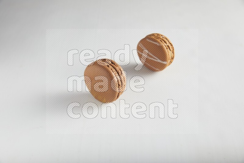 45º Shot of of two assorted Brown Irish Cream, and Brown Coffee macarons  on white background