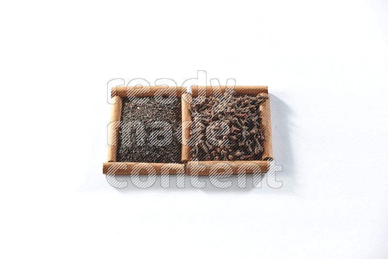 2 squares of cinnamon sticks full of black tea and cloves on white flooring