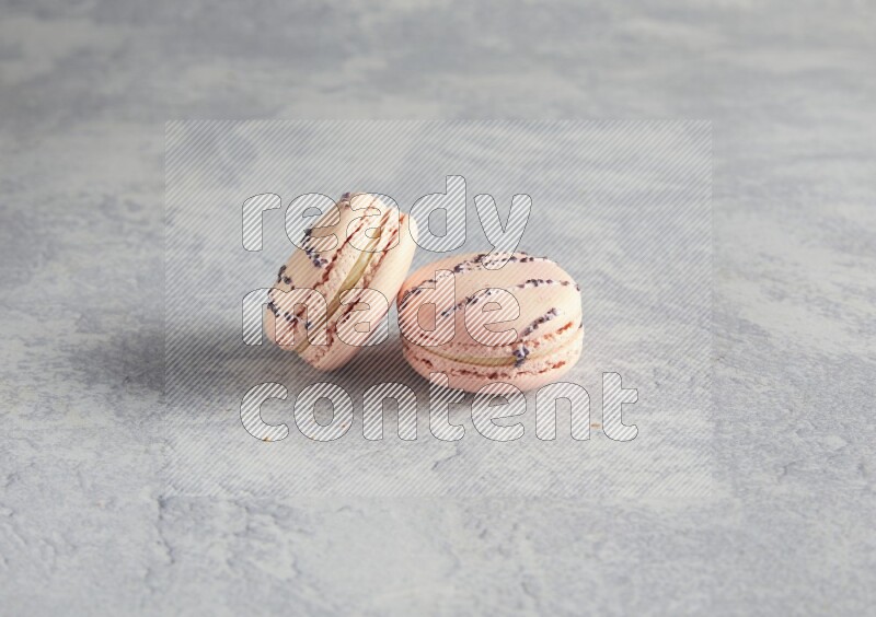 45º Shot of two pink orange blossom macarons  on white  marble background