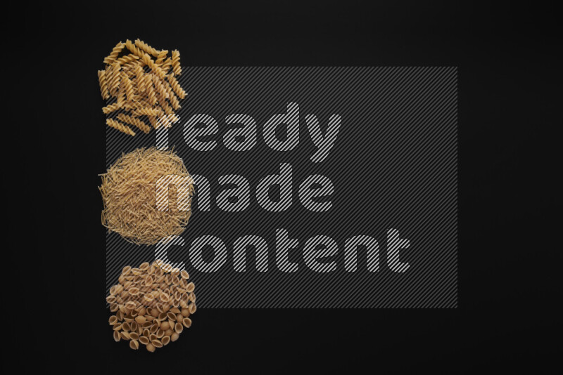 Different pasta types in 3 bunches on black background