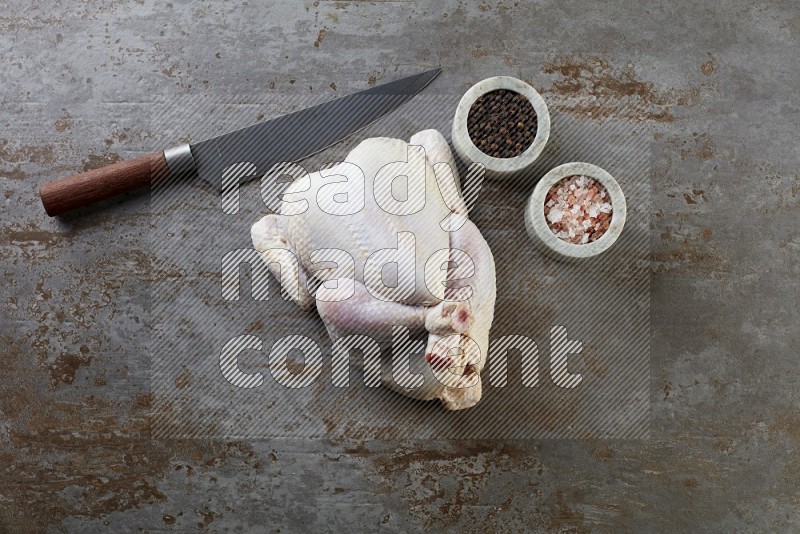 whole raw chicken  direct on a rustic grey background