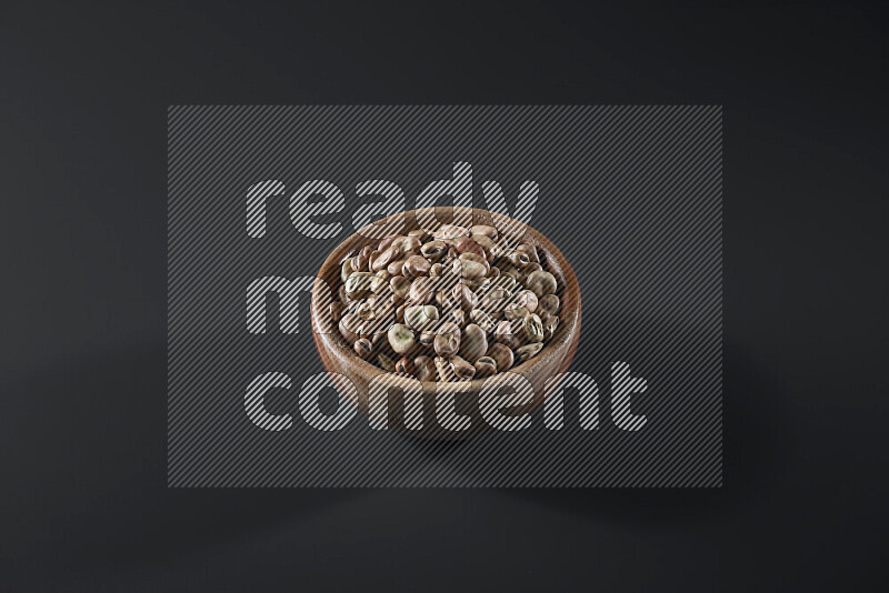 Fava beans in a wooden bowl on grey background