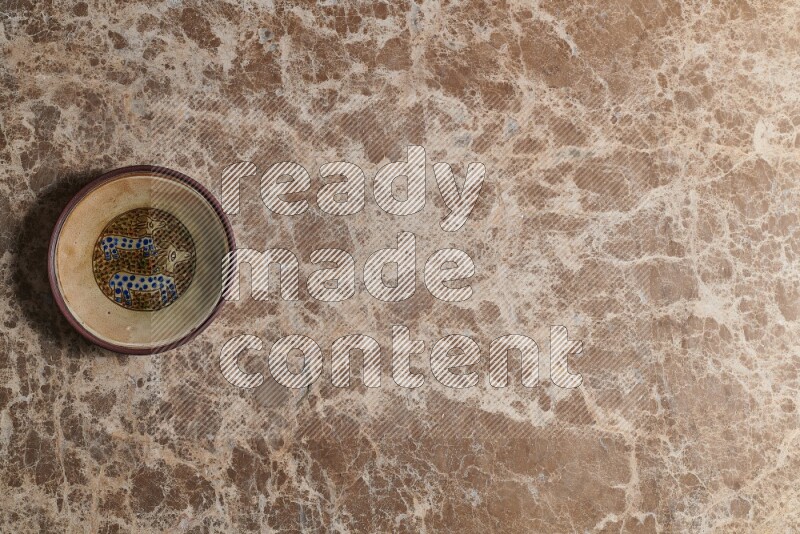 A decorative pottery plate on beige marble background