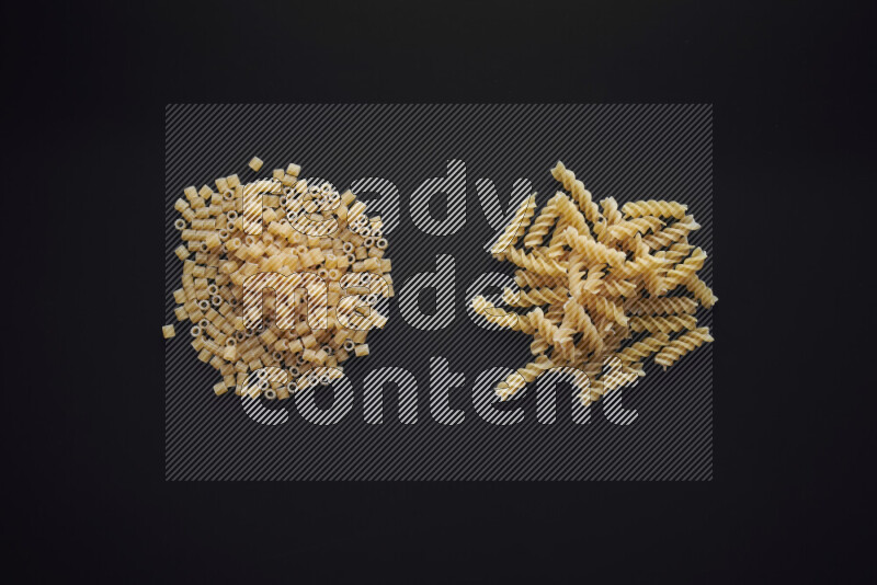 Different pasta types in bunches on black background