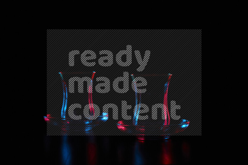 Glassware with rim light in red and blue against black background