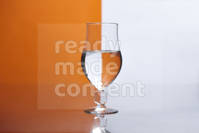 The image features a clear glassware filled with water, set against white and orange background