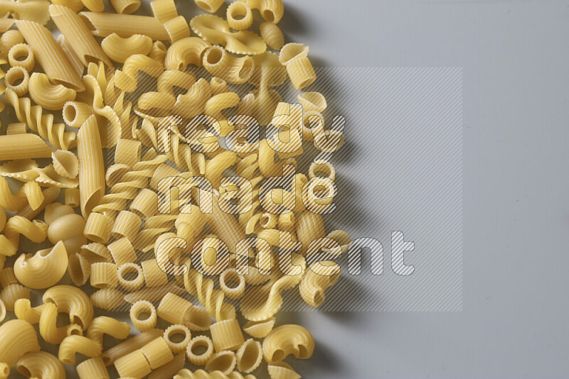 Different pasta types on light blue background