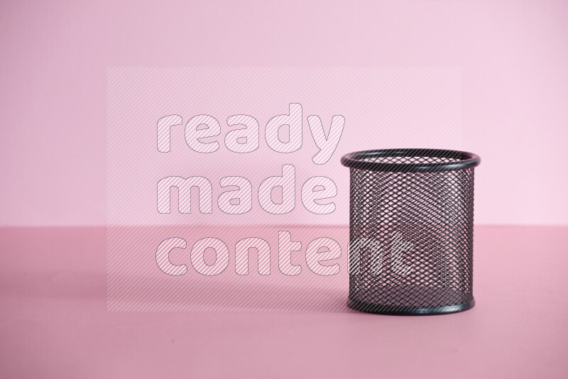 أقلام ومستلزمات مدرسية مختلفة أخري في حامل أقلام معدني على خلفية وردية