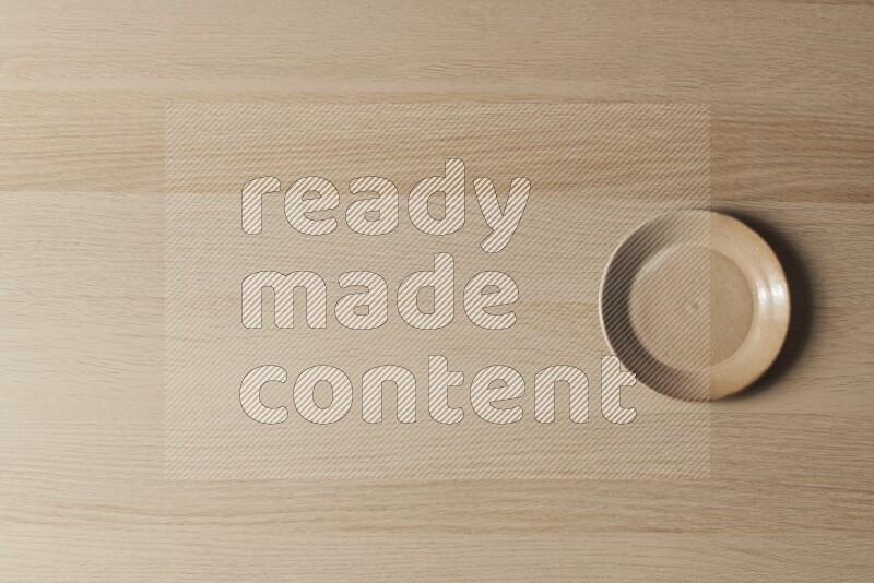 طبق من الفخار باللون البيج على خلفية خشبية فاتحة