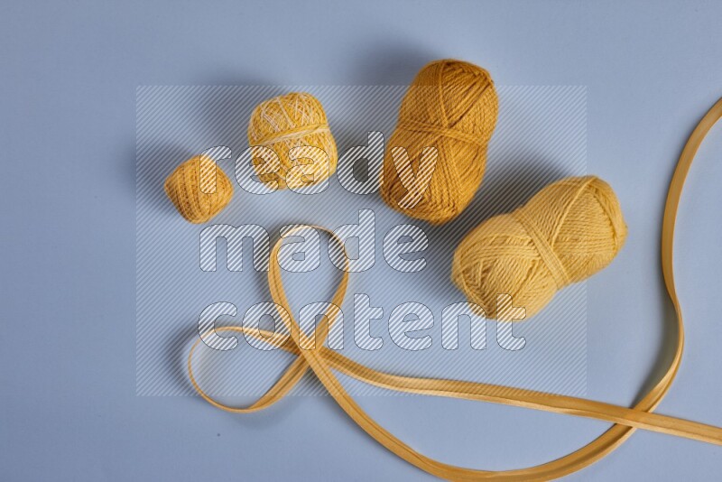 مجموعة من أدوات الخياطة والتفصيل صفراء اللون على خلفية زرقاء