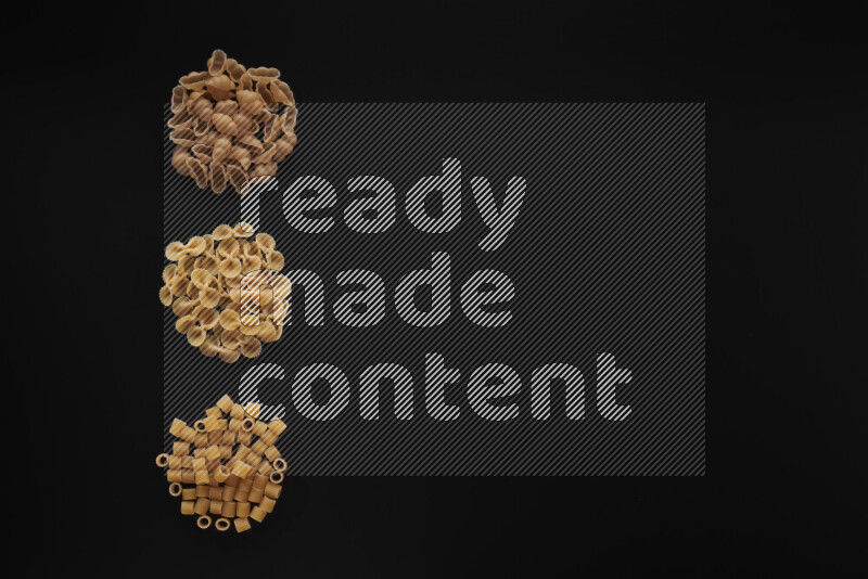 Different pasta types in 3 bunches on black background