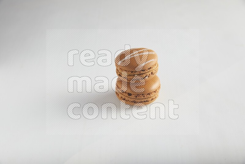 45º Shot of of two assorted Brown Irish Cream, and Brown Maple Taffy macarons  on white background