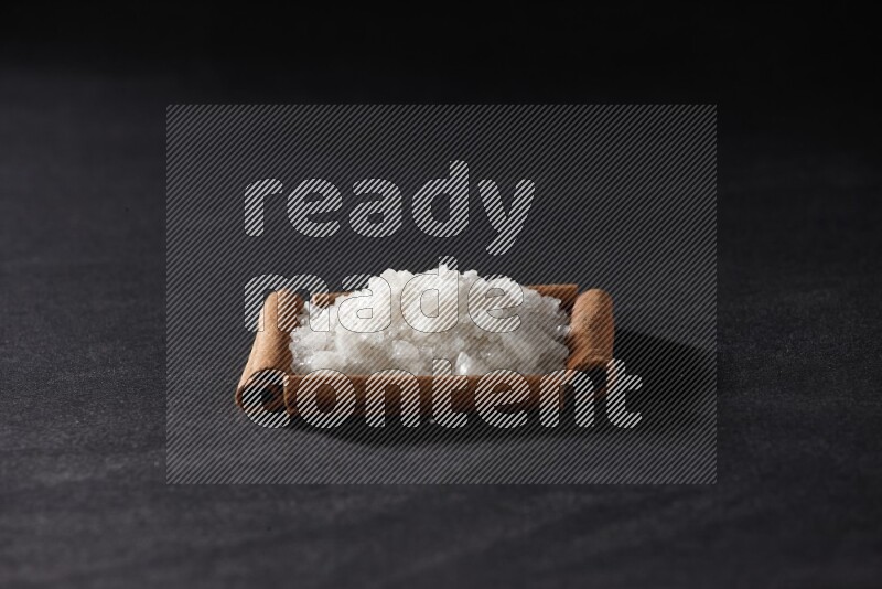 أربعة من أعواد القرفة مكونة شكل مربع بداخلها ملح أبيض علي خلفية سوداء