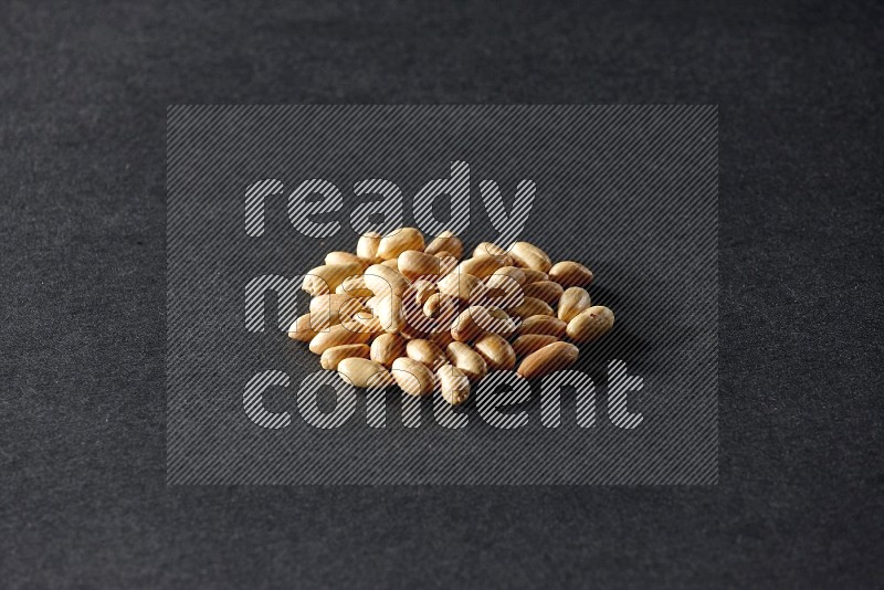 A bunch of peeled peanuts on a black background in different angles