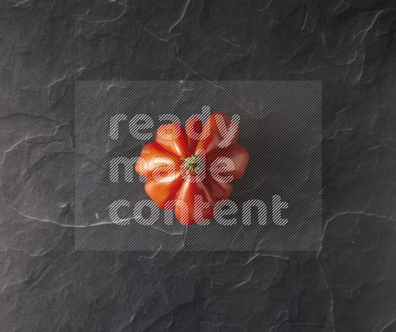 Single Topview Heirloom tomato on a black slate background