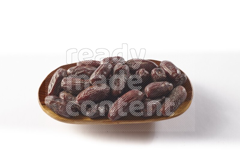 Dates in a wooden plate on white background