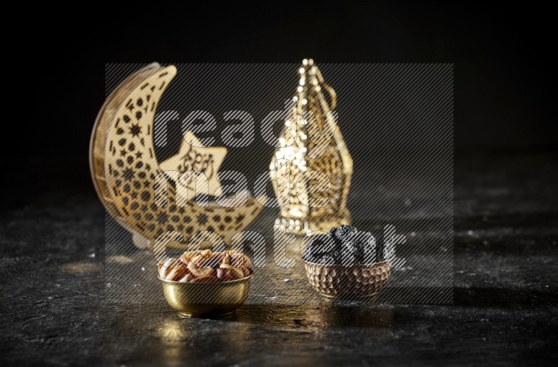 Nuts in a metal bowl with dried plums beside golden lanterns in a dark setup