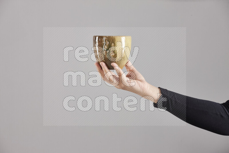 A woman in black abaya holding different pottery essentials in different positions