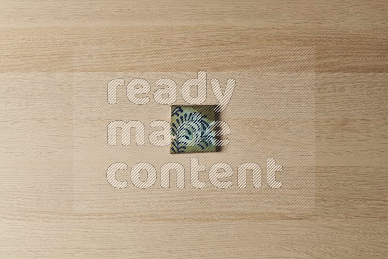 Top view shot of a pottery coaster\ tile on oak wooden flooring