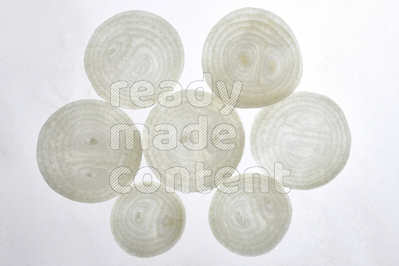 Onion slices on illuminated white background