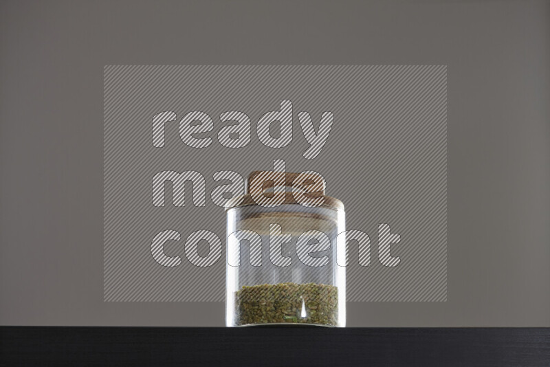 Freekeh in a glass jar on black background