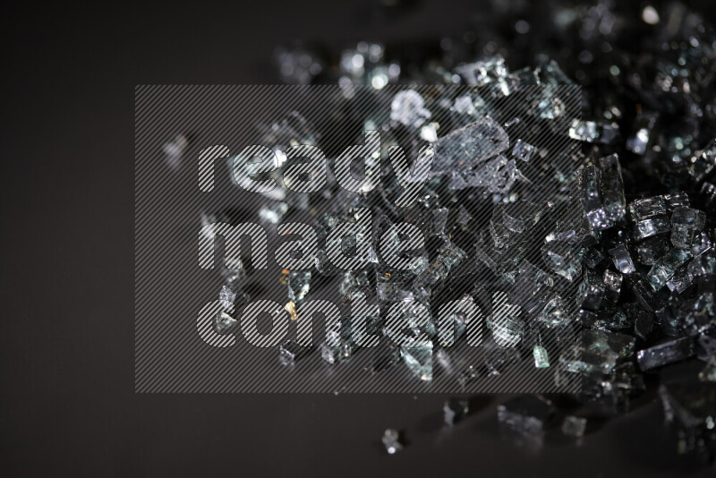 Transparent black fragments of glass scattered on a black background