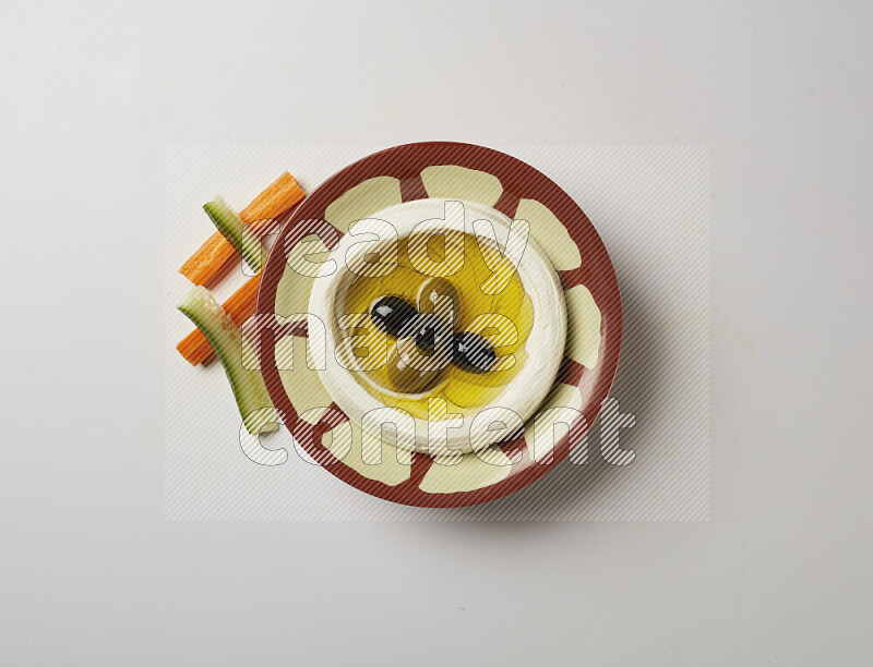 Lebnah garnished with olives in a traditional plate on a white background