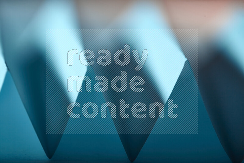 صورة مجردة مقربة تظهر طيات ورقية هندسية حادة بتدرجات اللون الأزرق