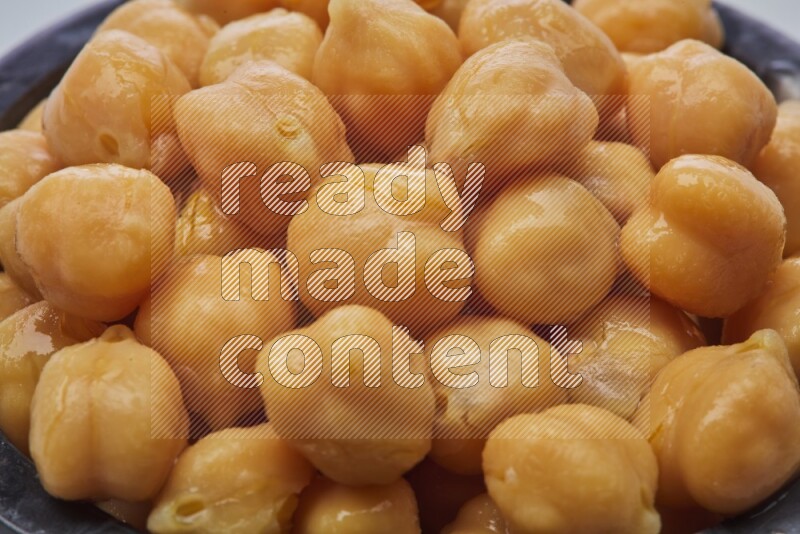 Close up of a boiled chickpeas in a container on white background