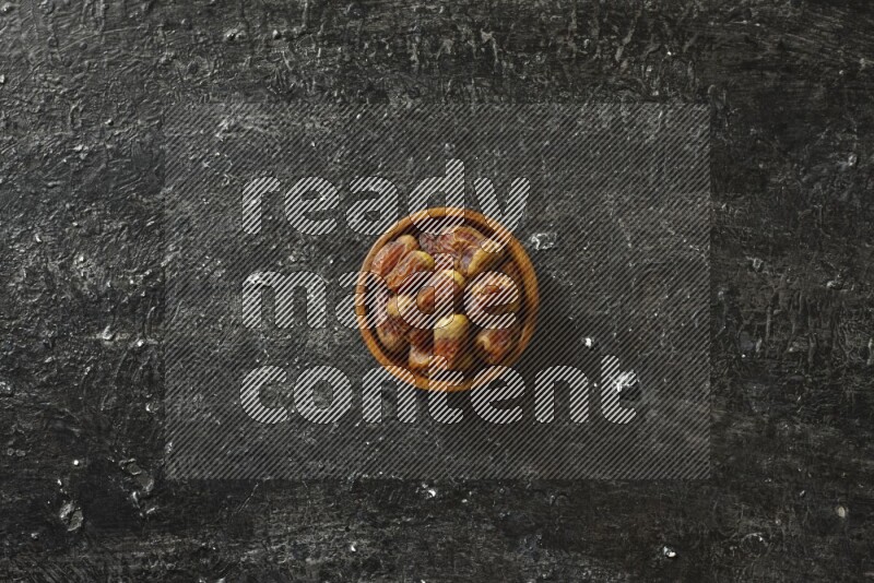 تمر في أطباق خشبية علي خلفية سوداء