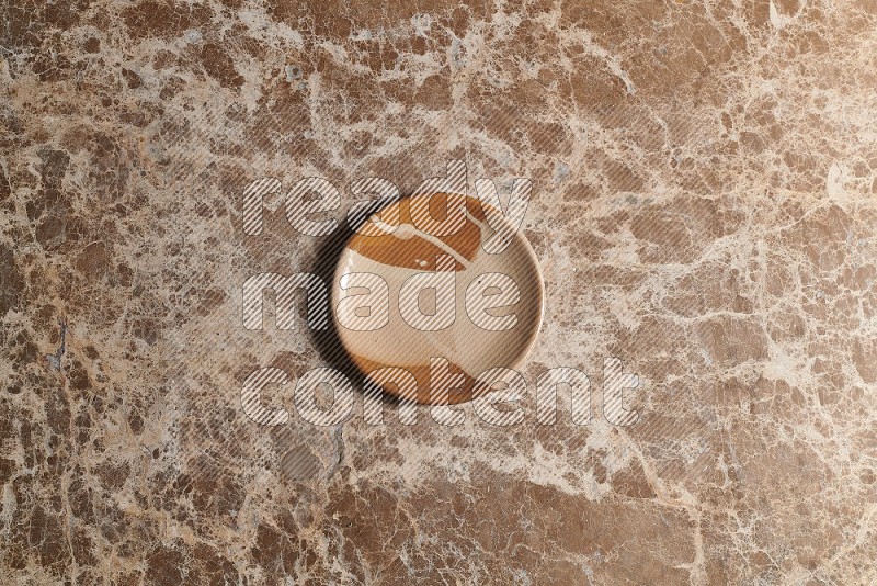 Top View Shot Of A Multicolored Pottery plate On beige Marble Flooring