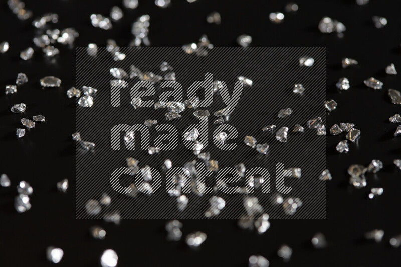 قطع زجاجية فضية لامعة متناثرة على خلفية سوداء