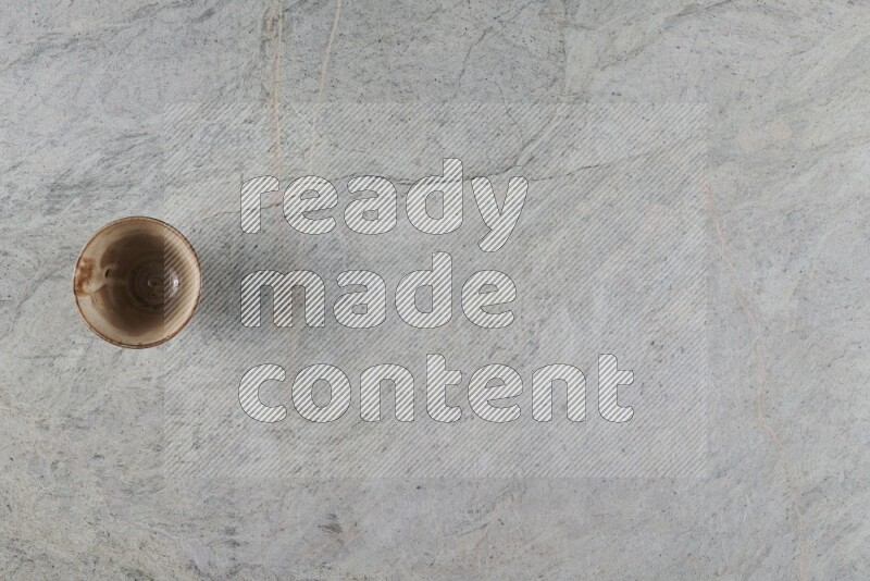 كأس فخاري متعدد الألوان على خلفية من الرخام الرمادي