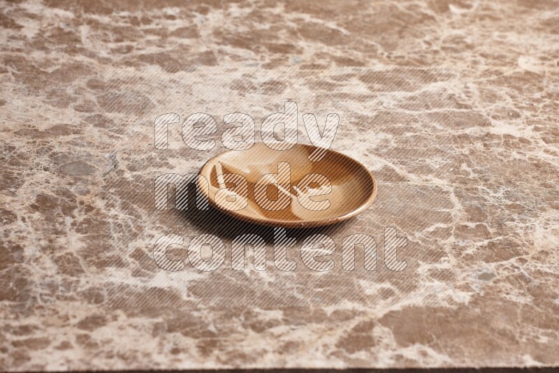 A multicolored pottery plate on beige marble background