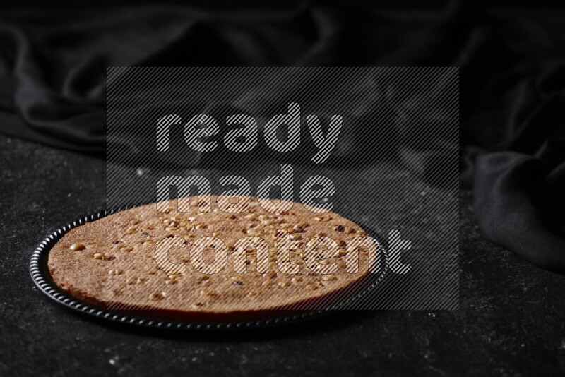 Basbousa in different plates in a dark setup