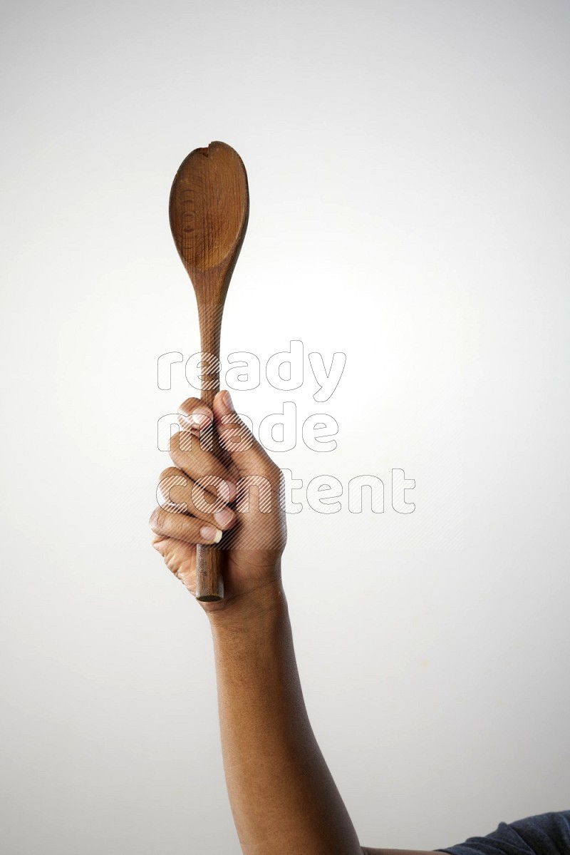 Male Hand Holding Wooden spoon on white background