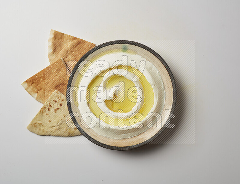 Lebnah garnished with olive oil in a pottery plate on a white background