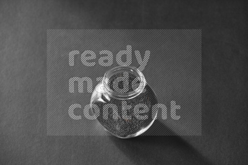 حبة البركة في وعاء زجاجي علي خلفية سوداء