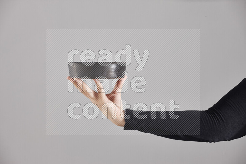 امرأة ترتدي عباءة سوداء تحمل أدوات فخارية مختلفة في أوضاع متعددة