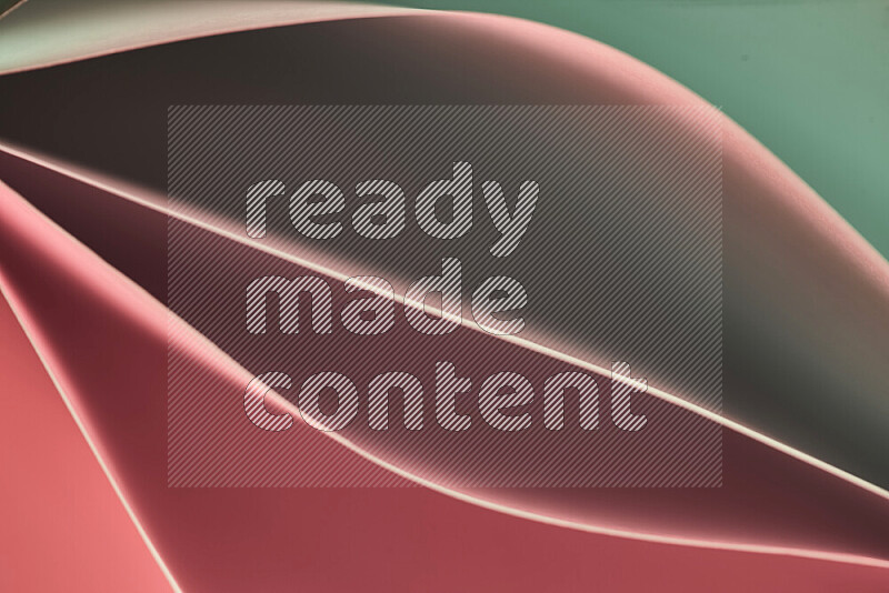 This image showcases an abstract paper art composition with paper curves in green and red gradients created by colored light